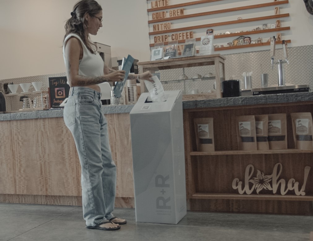 Customer depositing used coffee bags into R+R® Box.