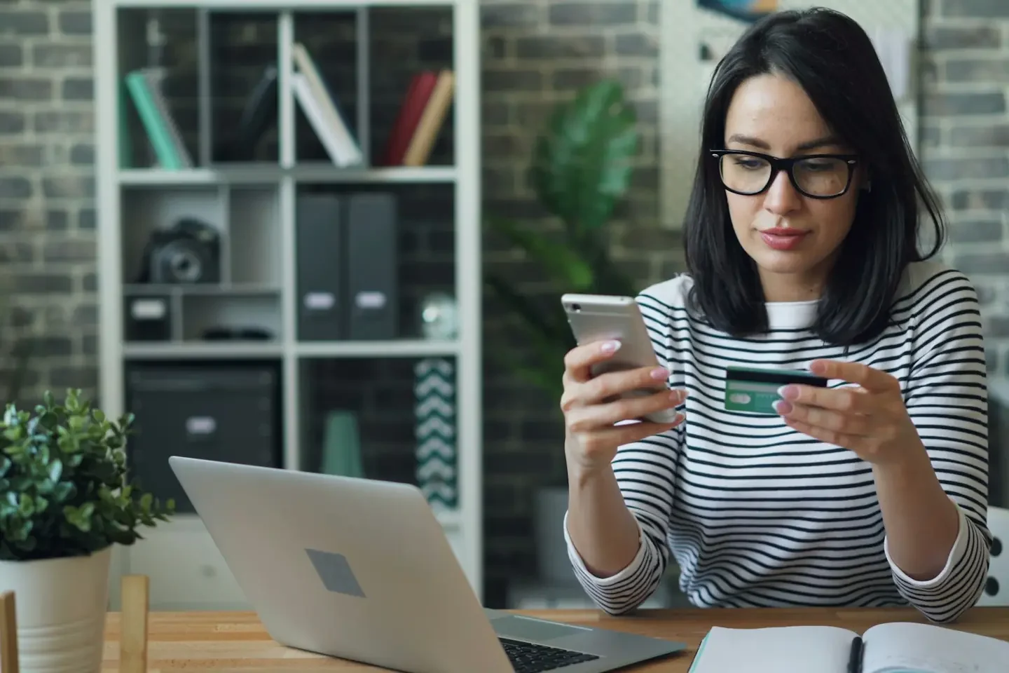 a woman sitting at a table looking at her cell phone