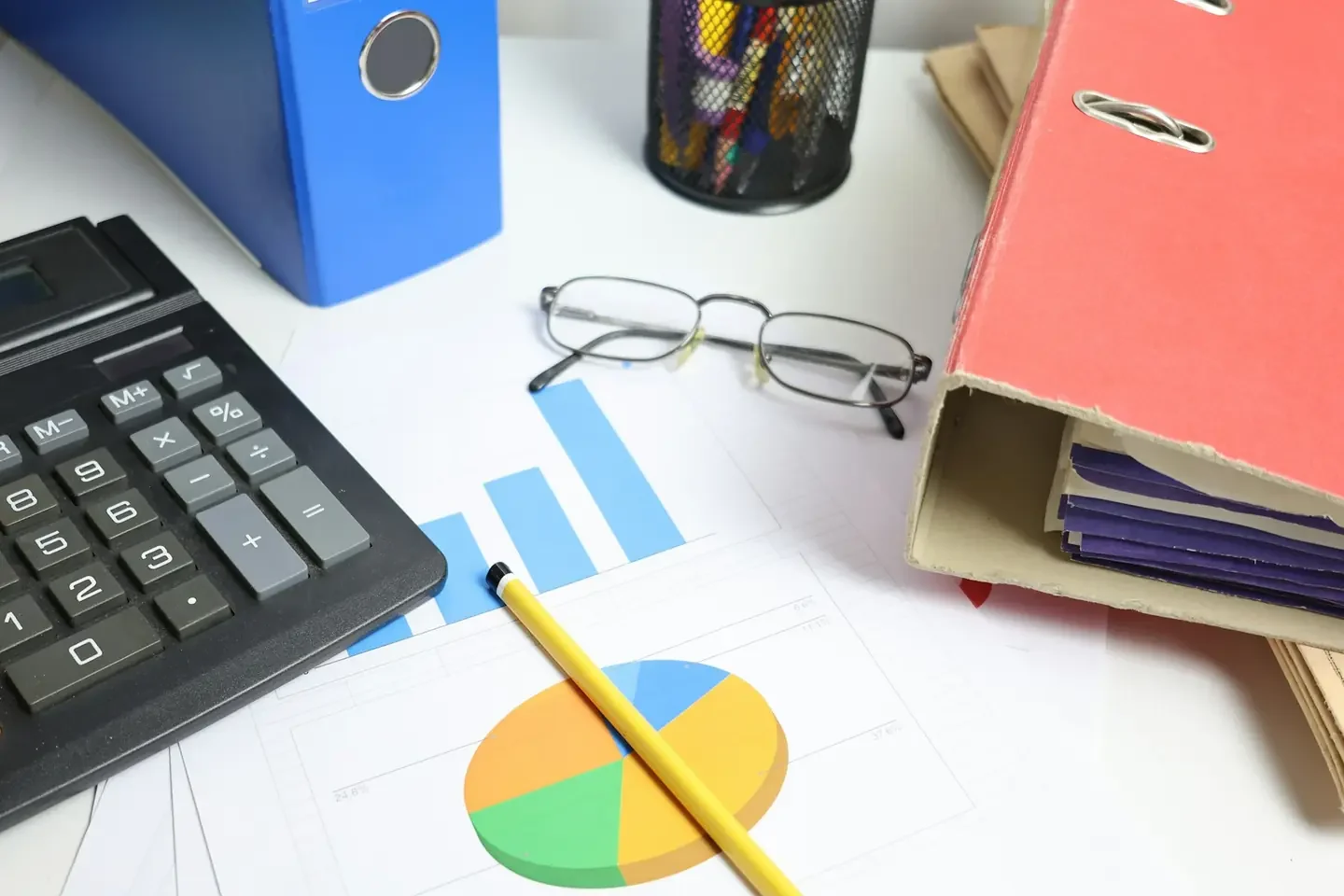 Desk with calculator, charts, and binders