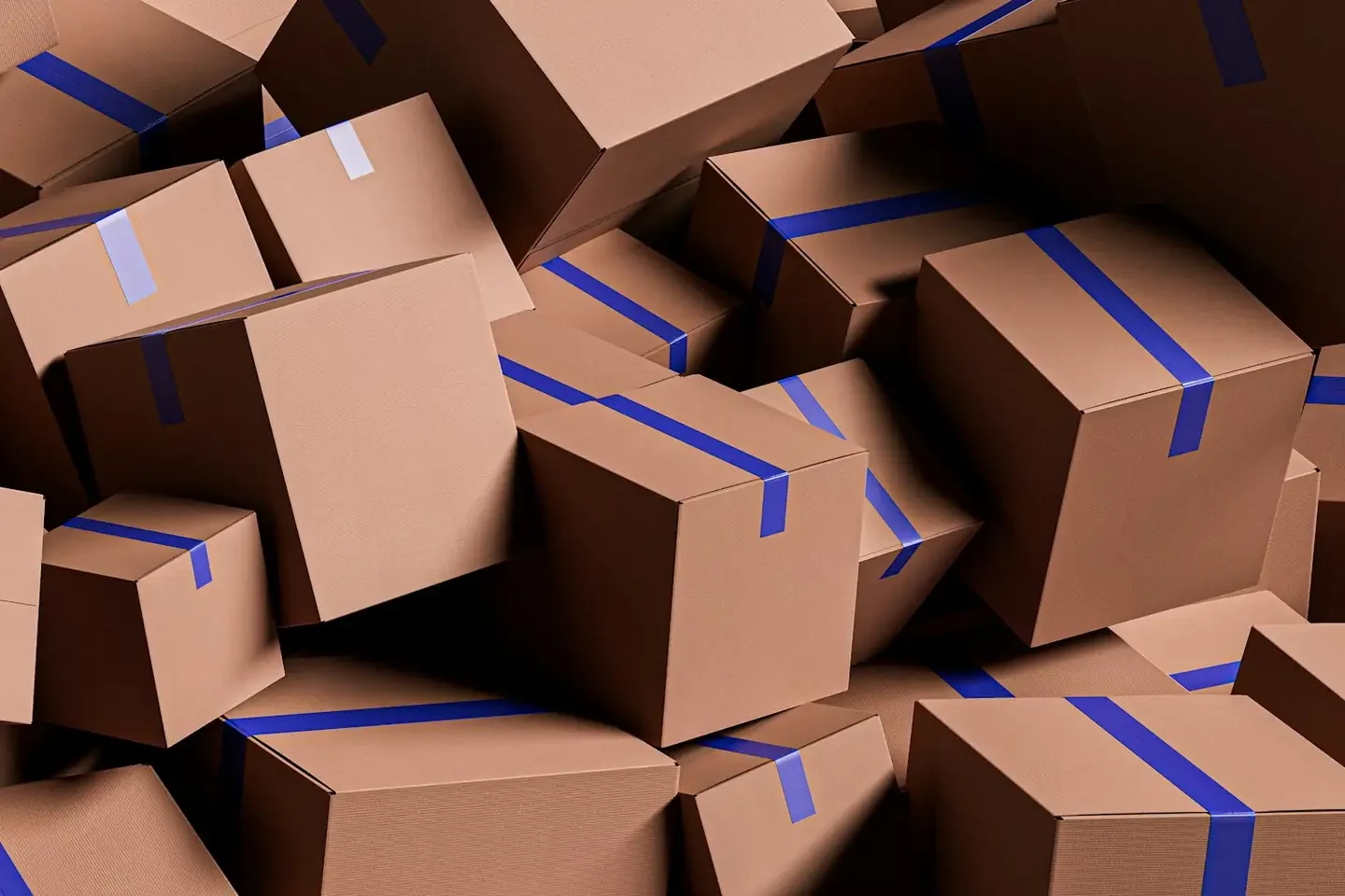A large pile of brown cardboard boxes with blue tape