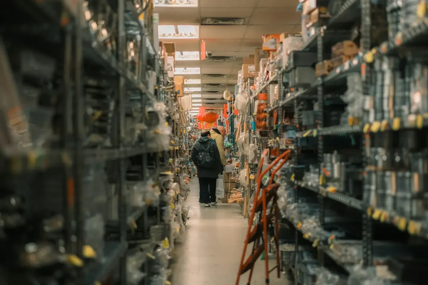 Person walks down aisle of stocked warehouse shelves