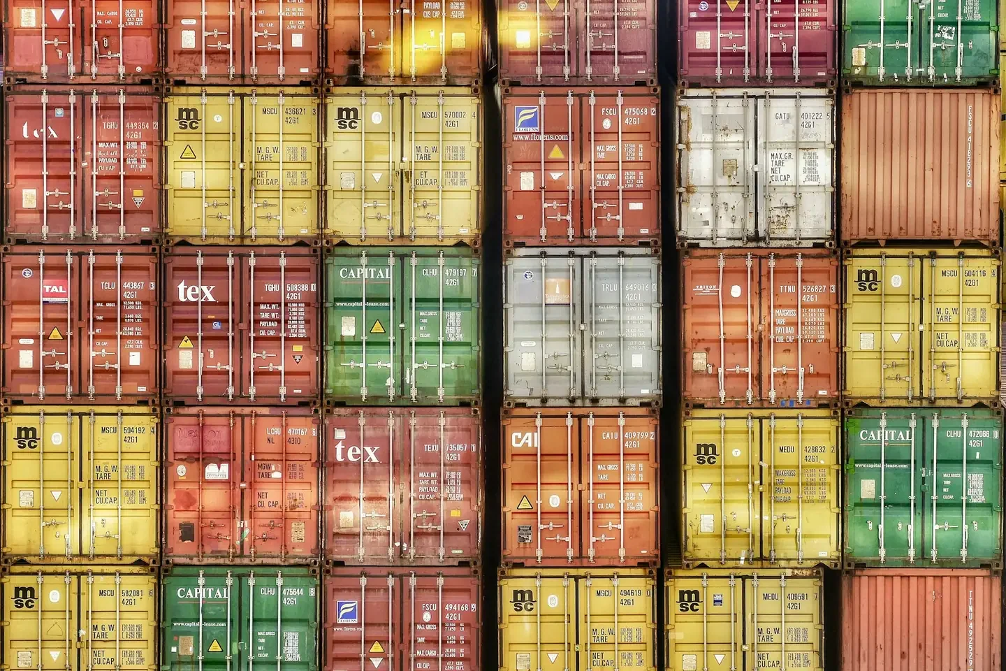 A wall of stacked colorful shipping containers