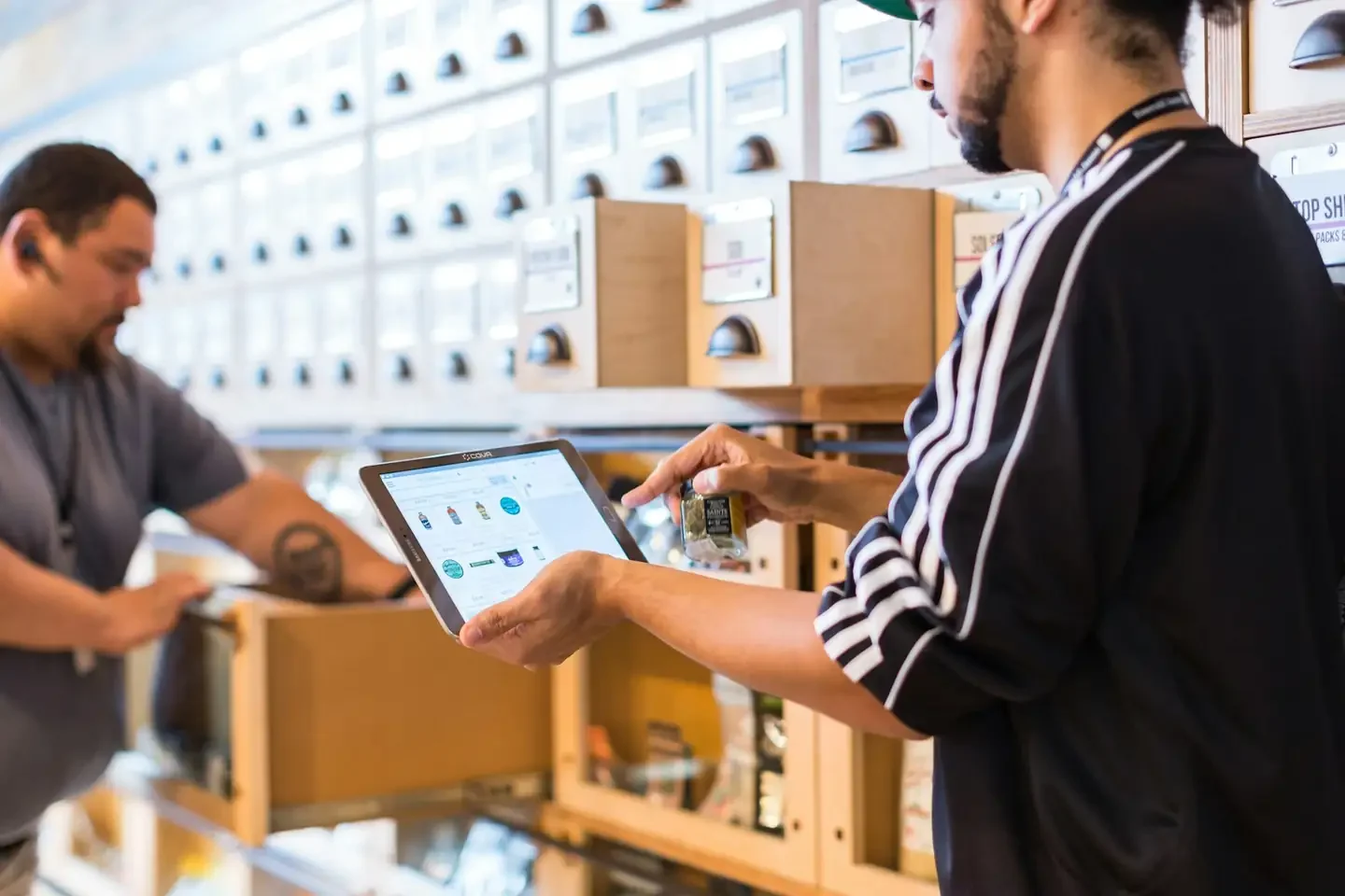 two men in a store looking at a tablet