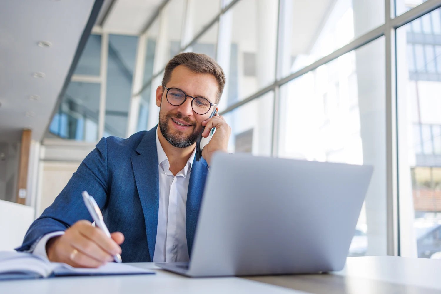 Photo of a professionally dressed man providing assistance over the phone