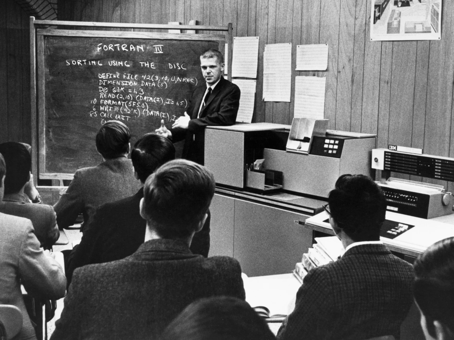 A monochrome photograph capturing a man speaking at a podium, conveying knowledge to an attentive audience.