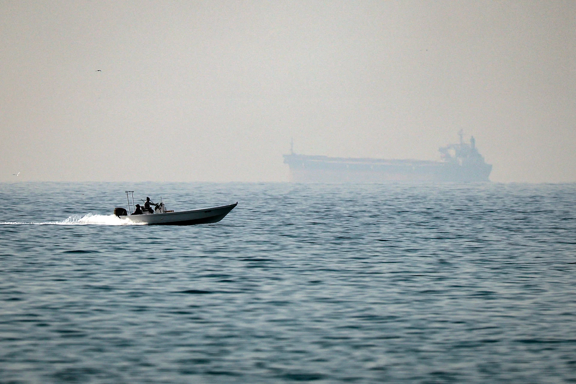 A motorboat cruises along the shore off the town of Al Jeer on the Strait of Hormuz