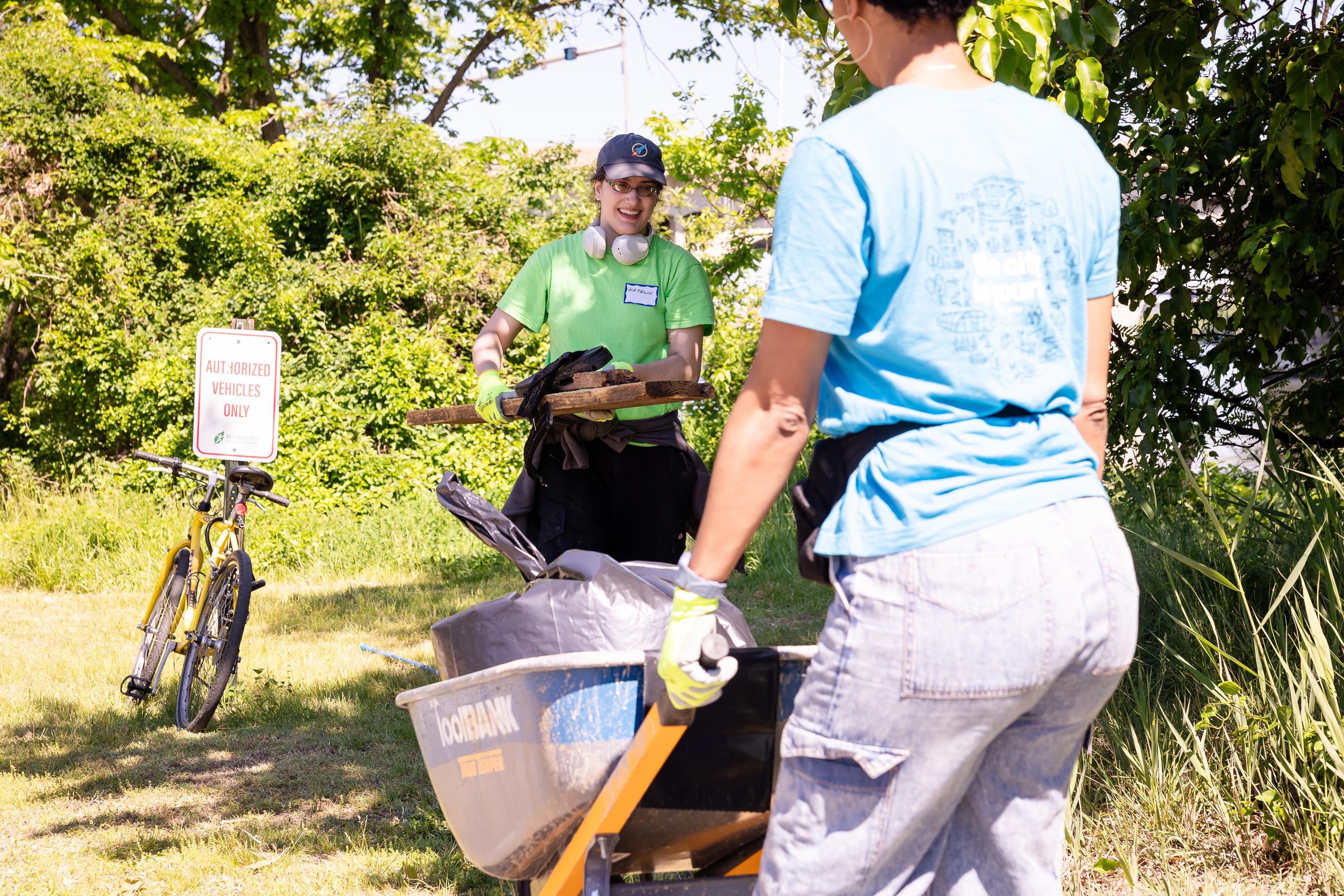 Participant loading debris into Christina's wheelbarrow.