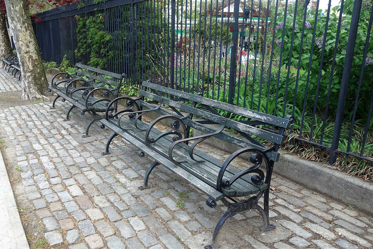 Examples of hostile architecture — these railings make it impossible to lay down and the fence blocks access to the park. Credit: Tdorante10 Wikimedia Commons