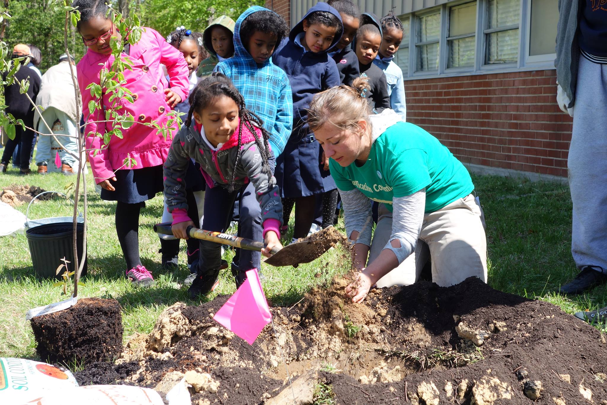 Kelley planting trees with students