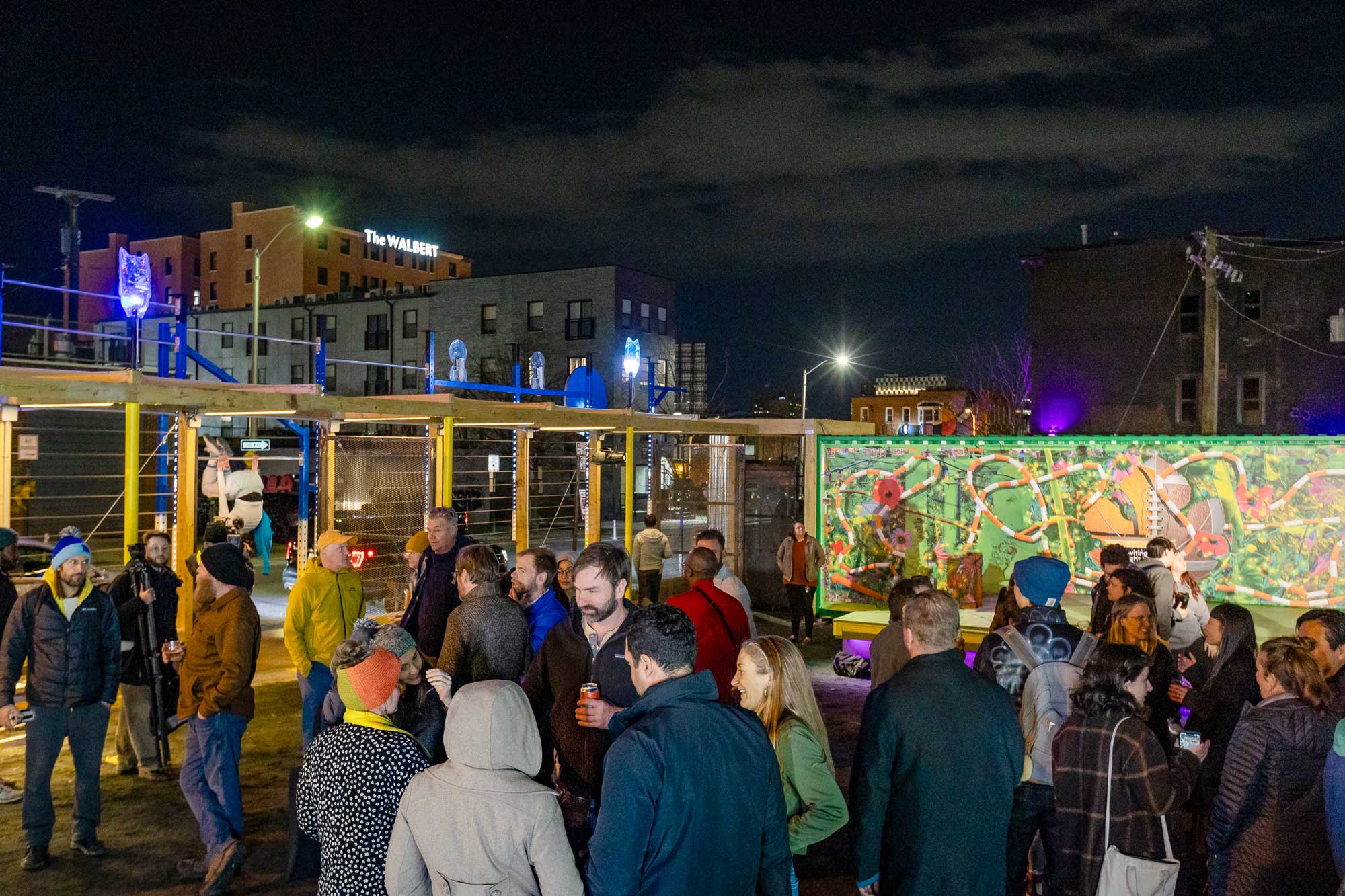 Soft Gym by Wickerham and Lomax, an Inviting Light installation at YNOT LOT in Station North Arts District. Night unveiling event shows crowd in exercise pavilion.
