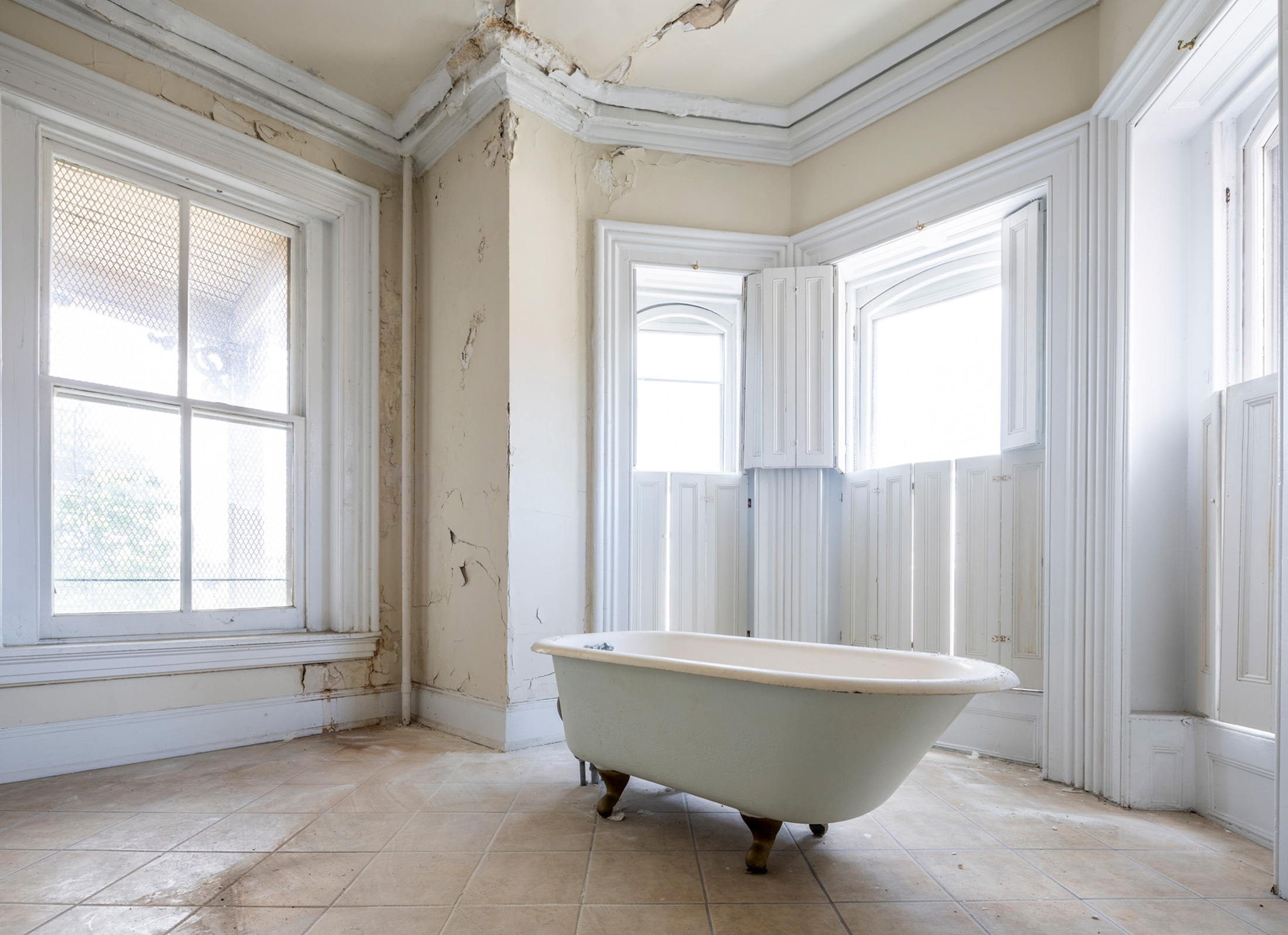 Existing conditions of Parren Mitchell House before construction — roomy bathroom with clawfoot tub.