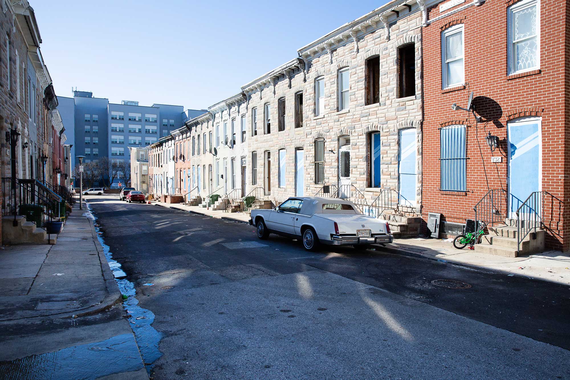An austere block in Johnston Square, Baltimore before redevelopment. No trees or people and half the homes are vacant.
