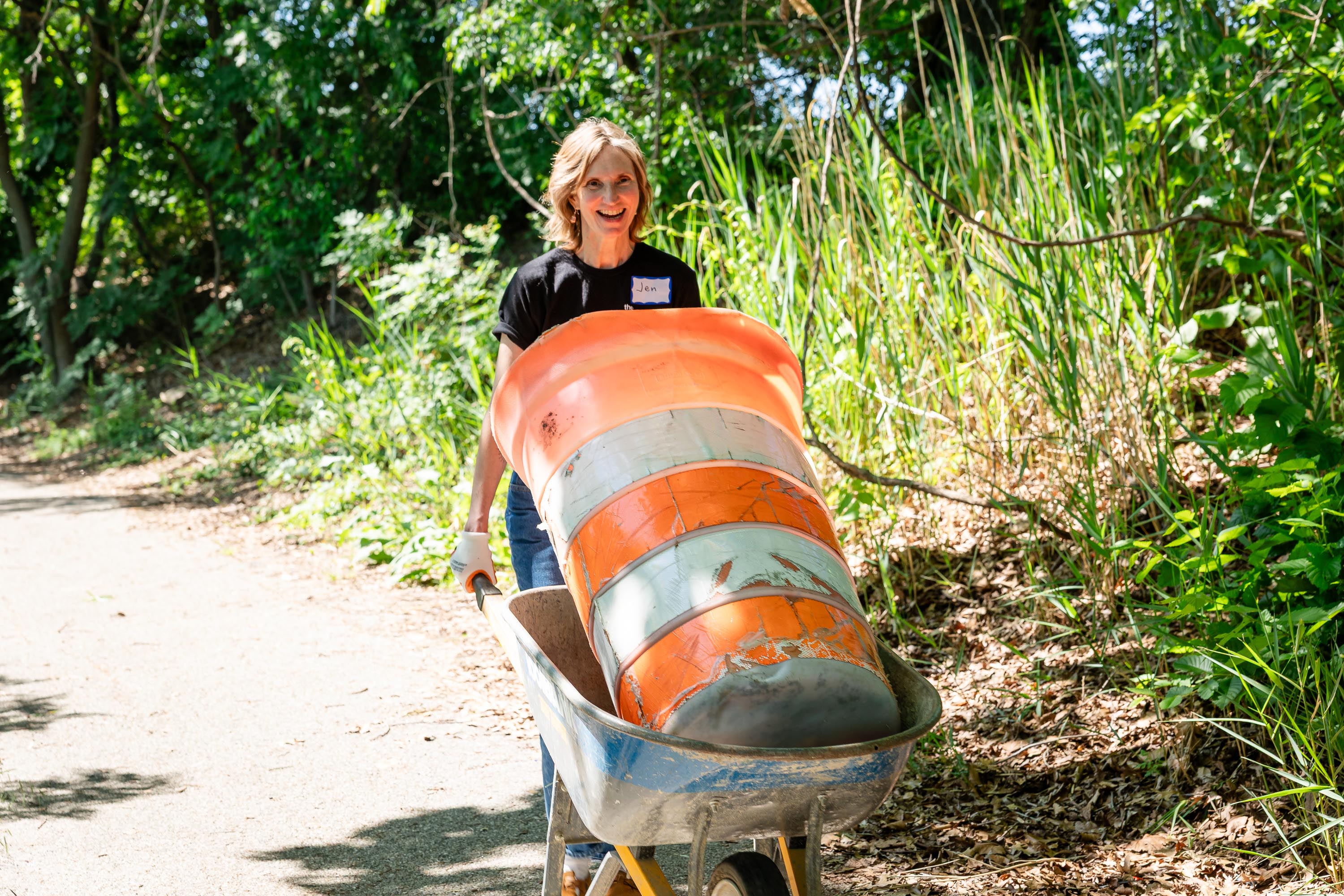 NDC Director Jen Goold pushing wheelbarrow.