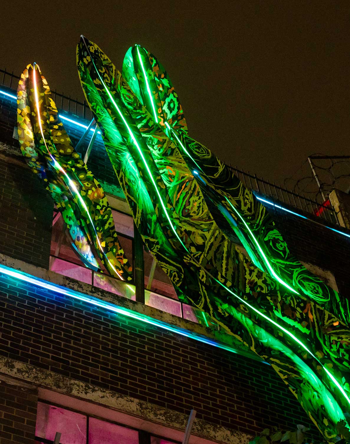 Light installation by Phaan Hwong in Station North. This Inviting Light piece shows larger-than-life leaves illuminating a parking garage. 