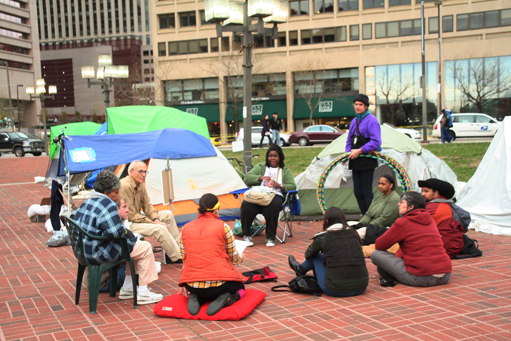 Occupy Movement participants in discussion within encampment in KcKeldin Square, downtown Baltimore, 2011. Flickr photo by KimsWorldofArt.
