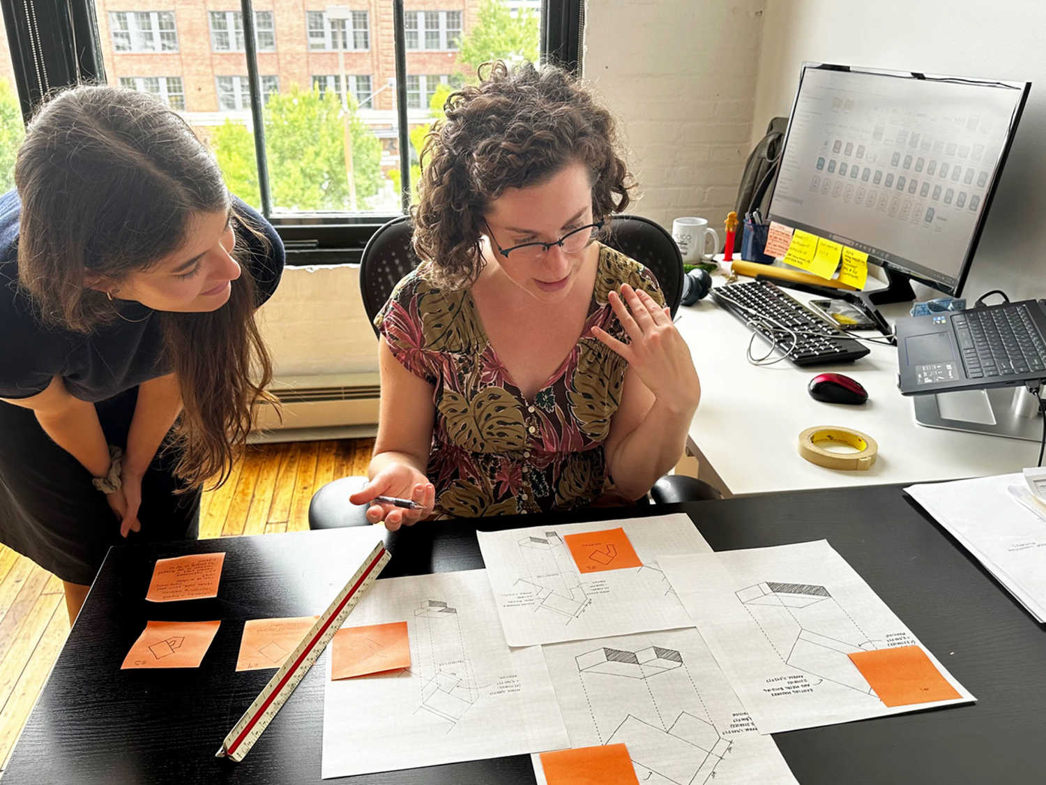 NDC staff members Julia and Karla review project plans at our Baltimore office.