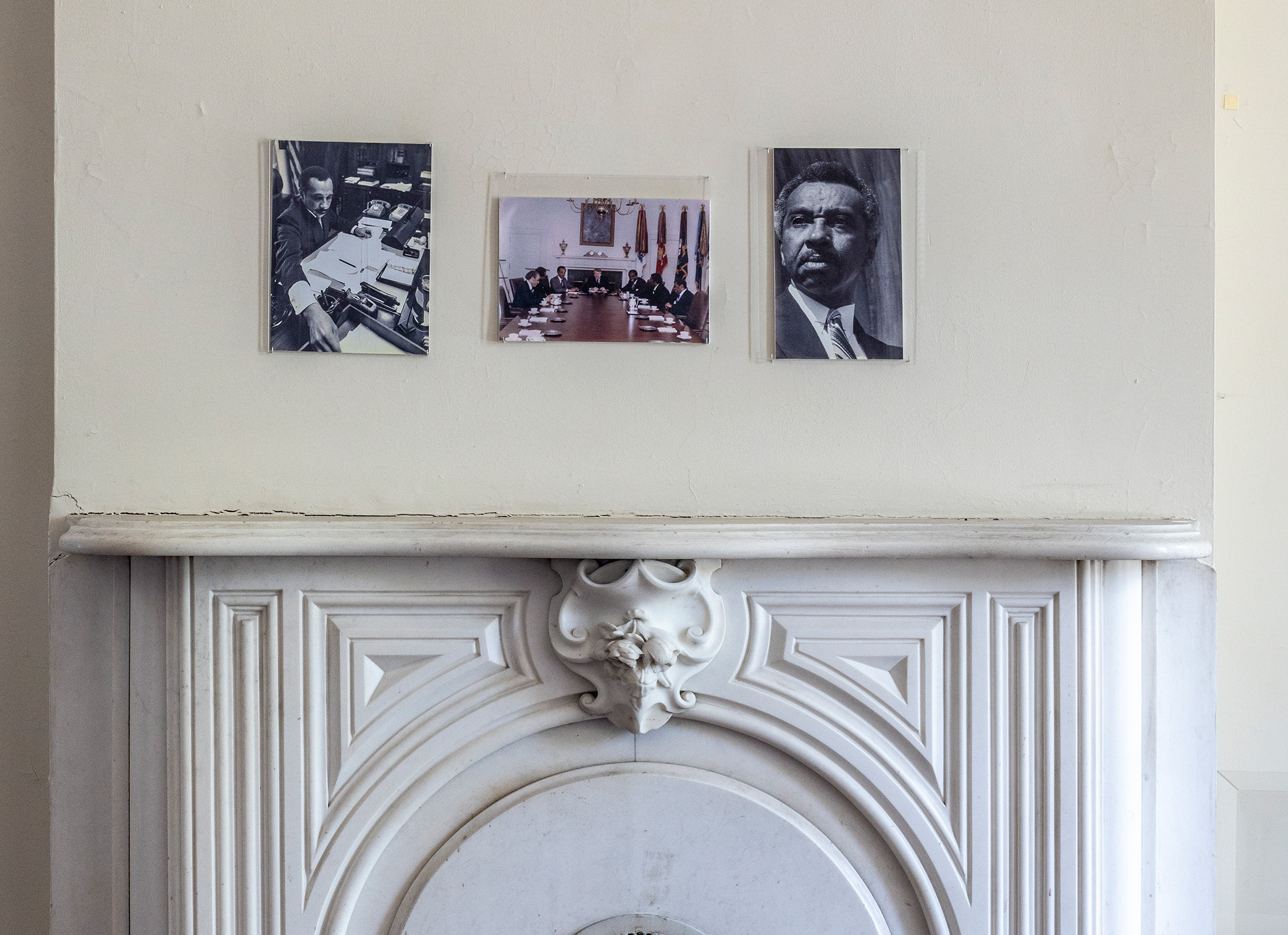 Existing conditions of Parren Mitchell House before construction — photos of Mr. Mitchell above fireplace.