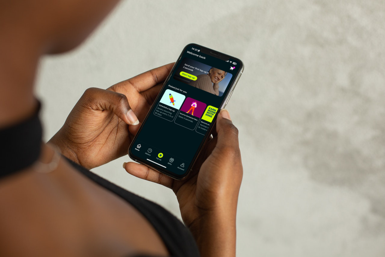 una persona che utilizza Ding sul proprio cellulare per inviare una ricarica internazionale