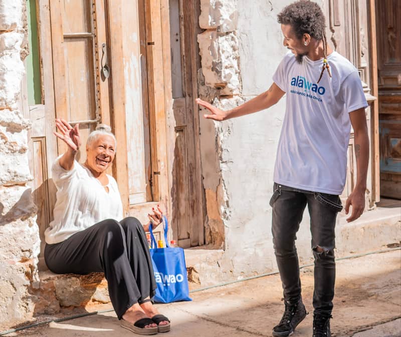 Hombre sonriendo con una camiseta de Alawao saludando a una mujer Cubana