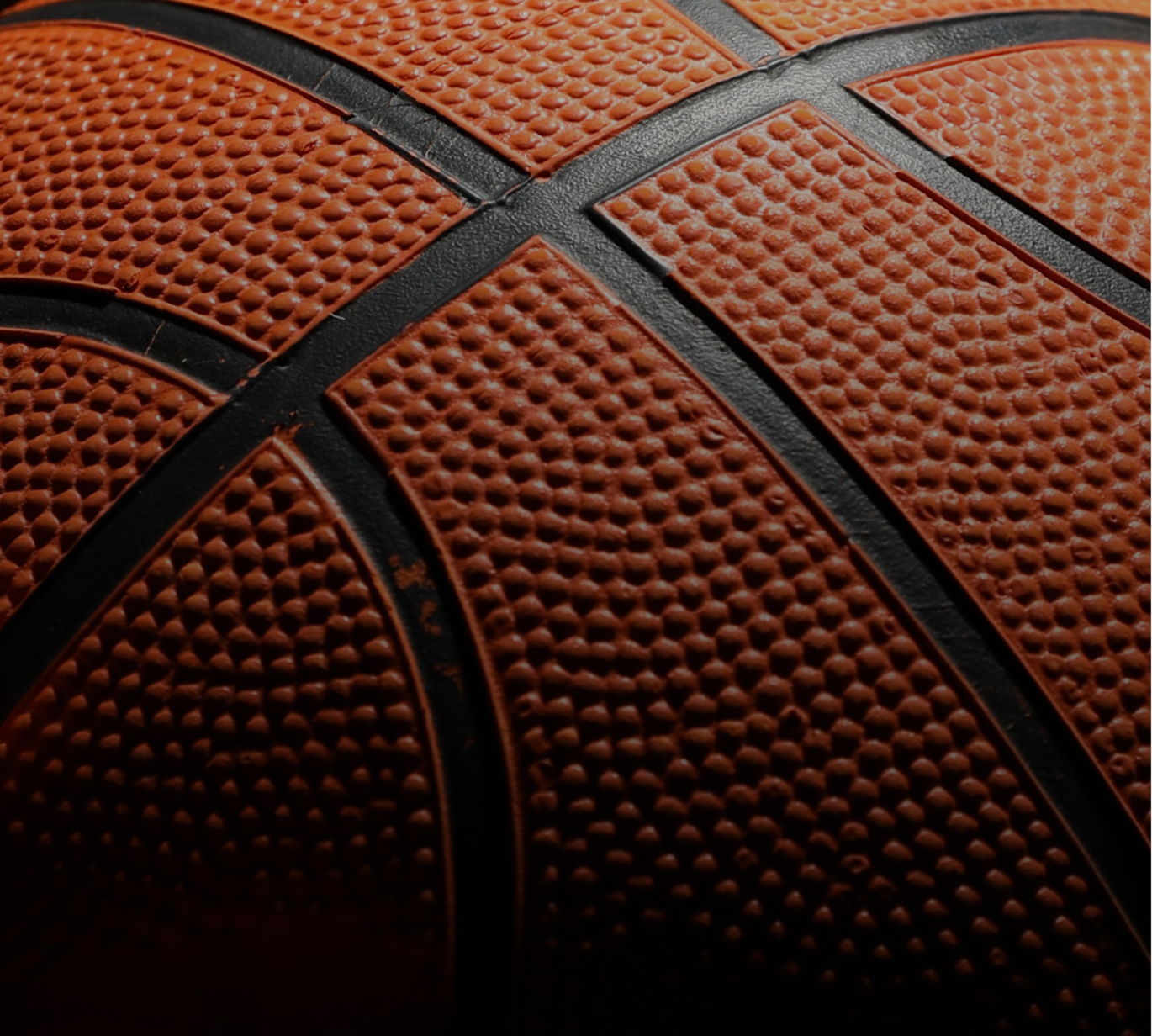 A close-up of a basketball reveals the detailed texture and grip that define the game, symbolizing precision, control, and the foundation of every play on the court.