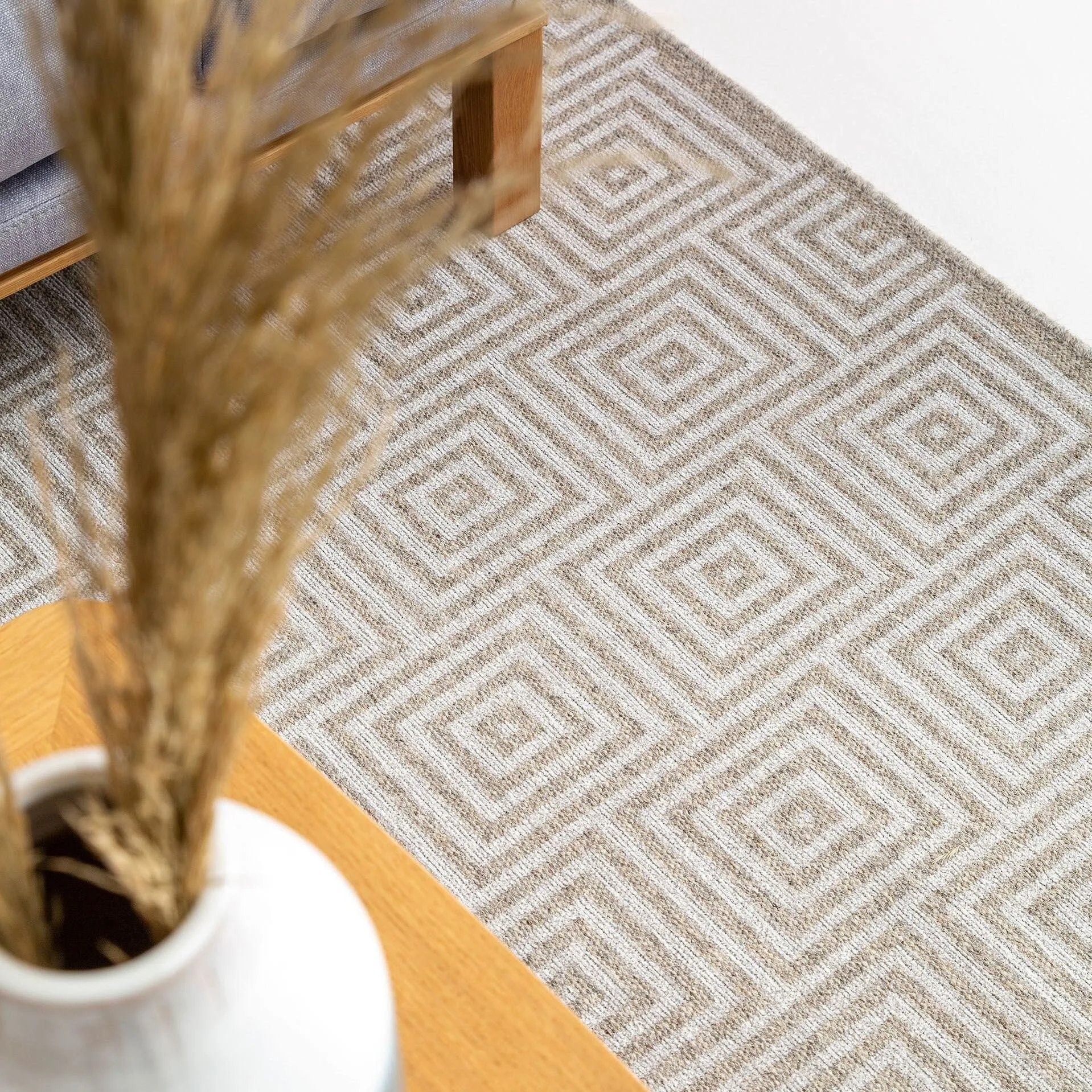 Nahaufnahme auf einen beige-braunen Teppich mit geometrischem Muster