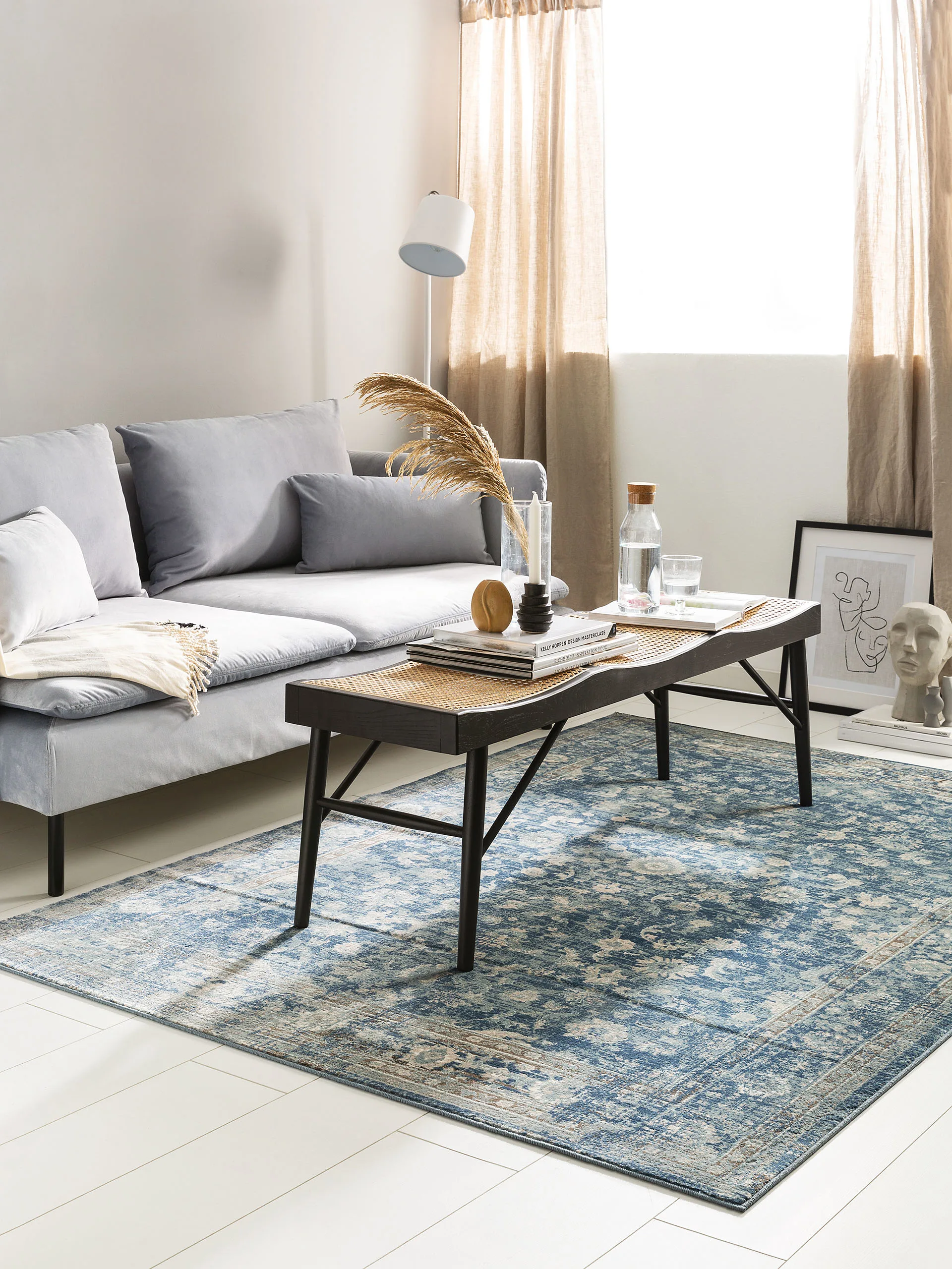 Günstig eingerichtetes Wohnzimmer mit grauem Zweiersofa, kleinem Couch-Tisch und preiswerten Vintage-Teppich in Petrol von benuta Pop