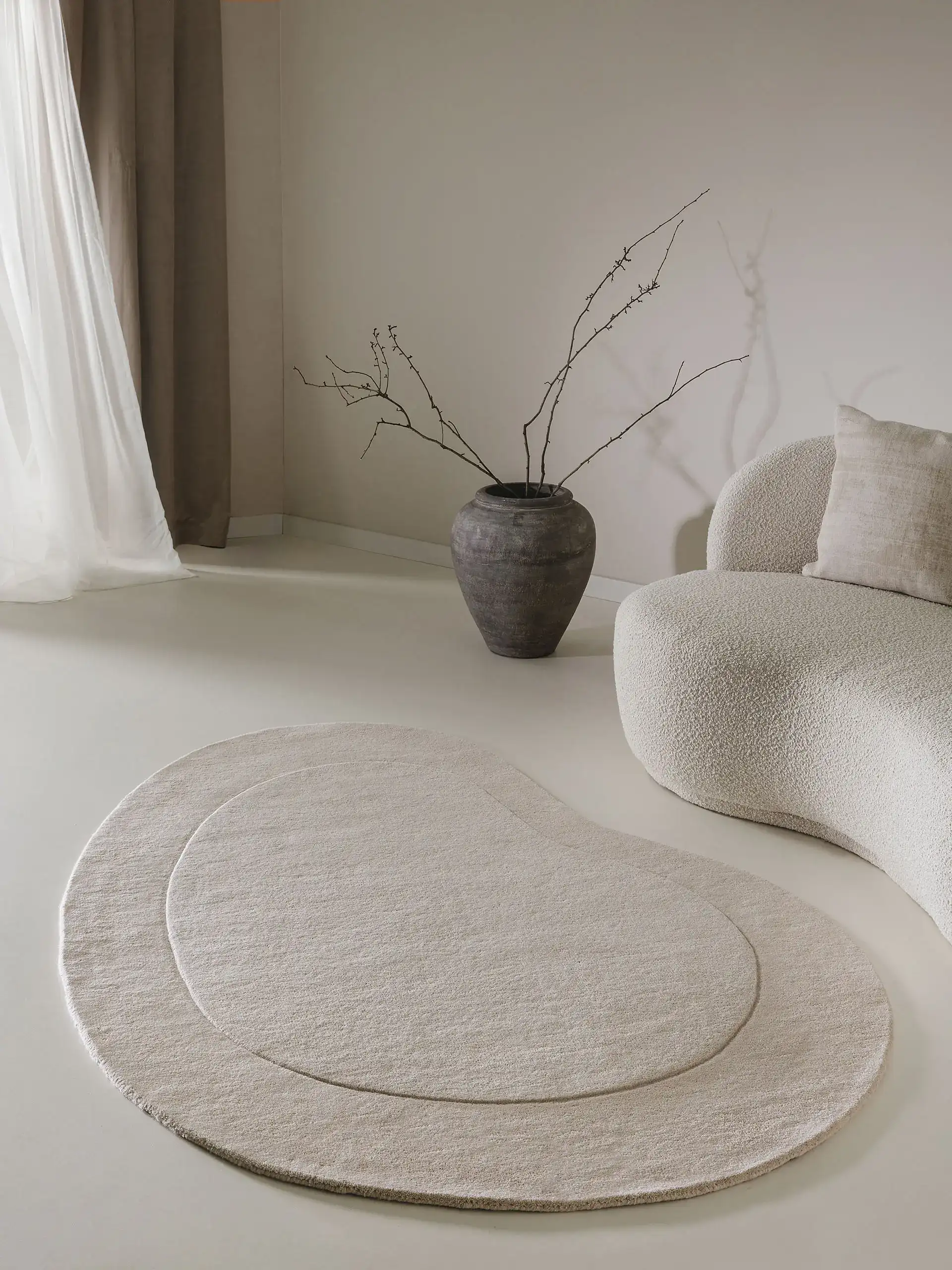 Organischer, kleiner Teppich für die Fußbodenheizung in einem luxuriösen Wohnzimmer mit Couch in S-Form