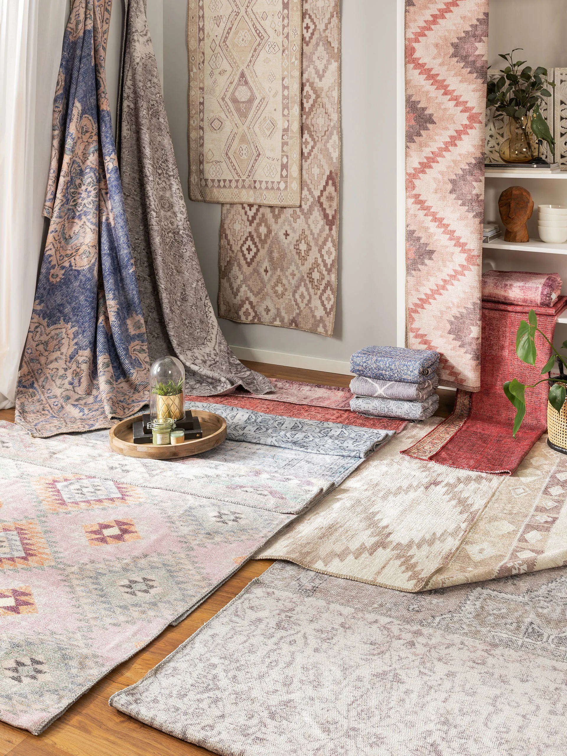 Viele verschiedene Teppiche im Ethno Style schon drapiert in einem Raum auf dem Boden und an der Wand