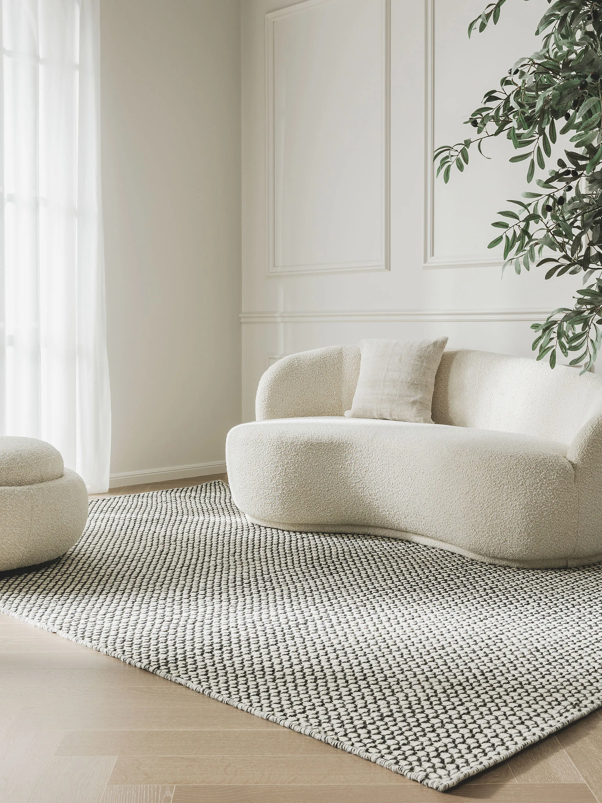 Schwarz-weißer Flachgewebe Teppich mit der perfekten Größe, um Sofa und Pouf in Beige auf ihn zu platzieren
