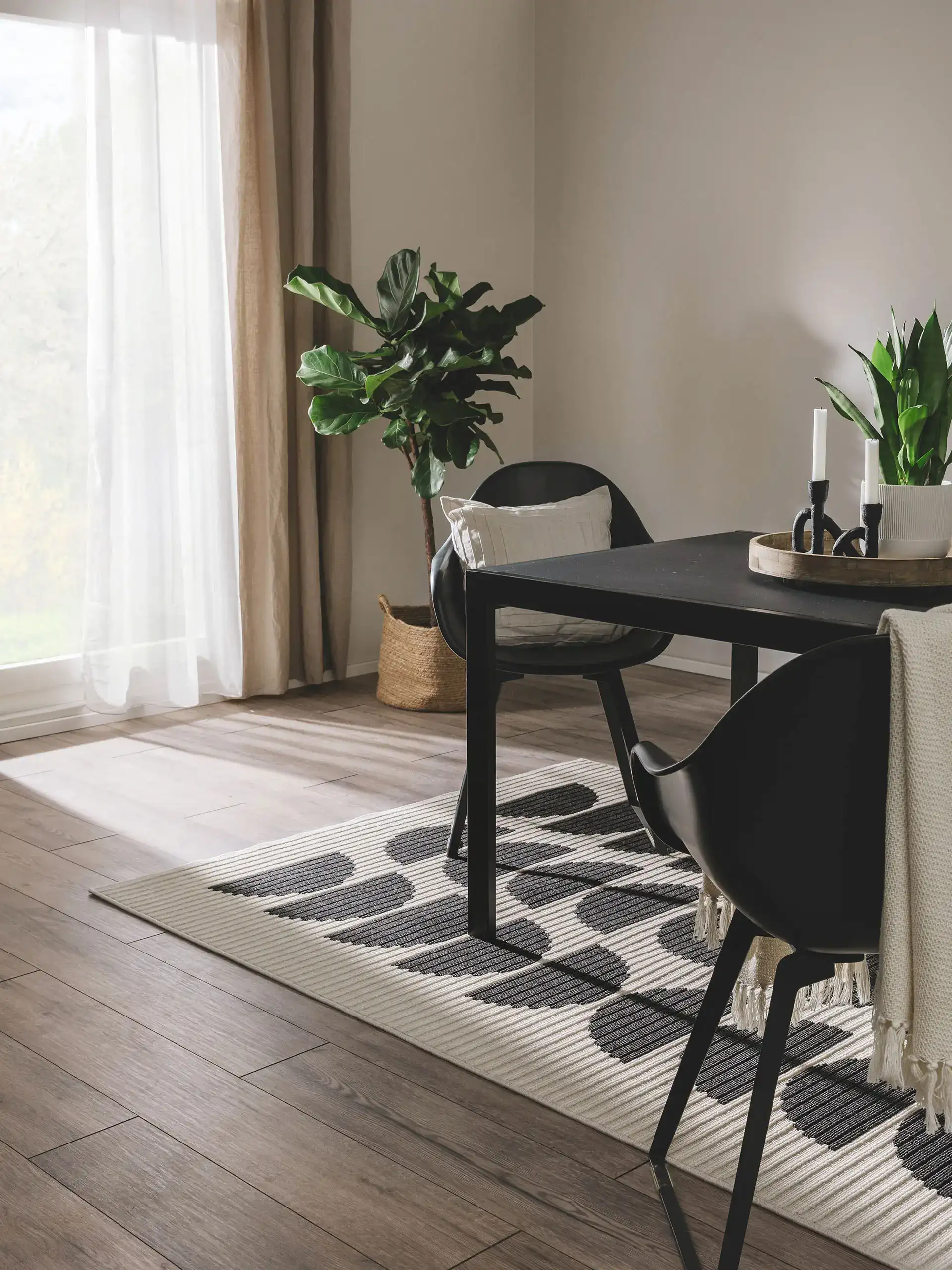 Essecke mit schwarzem Esstisch, schwarze Stühlen und Flachgewebeteppich auf deinem Holzparkett mit Fußbodenheizung