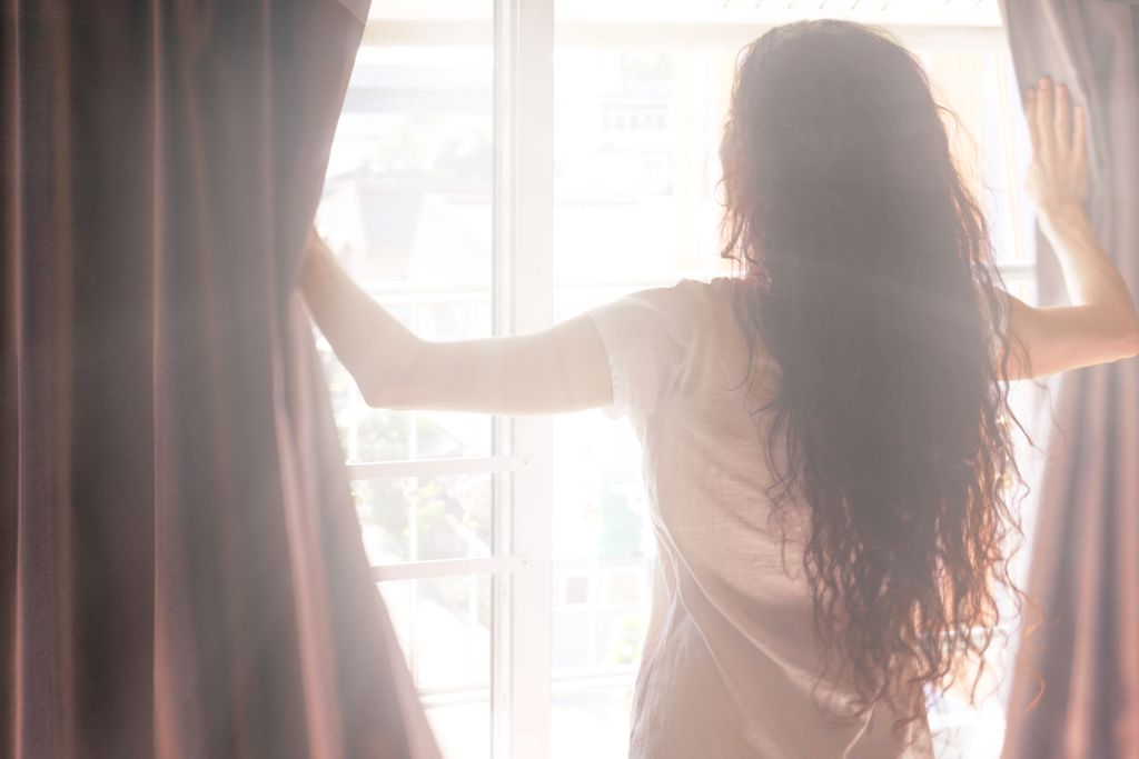 woman-opens-the-curtains-in-the-morning-2024-12-04-12-10-06-utc