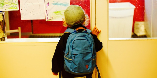 child in front of a board first day at school