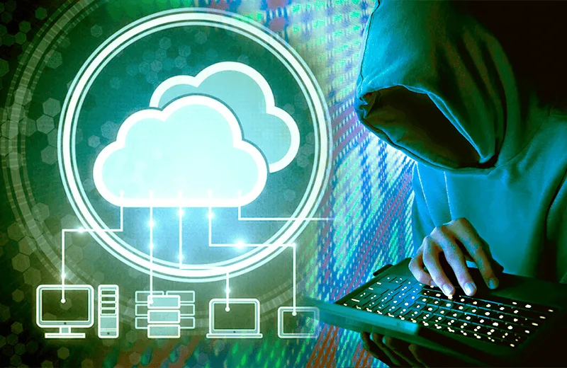 A hooded figure types on a laptop, symbolizing hacking or cybercrime. A glowing cloud network icon represents digital data security, set against a colorful, abstract background.