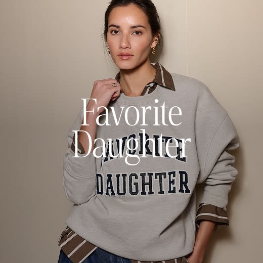Model wearing an over-sized gray graphic crew-neck that reads “Favorite Daughter.”