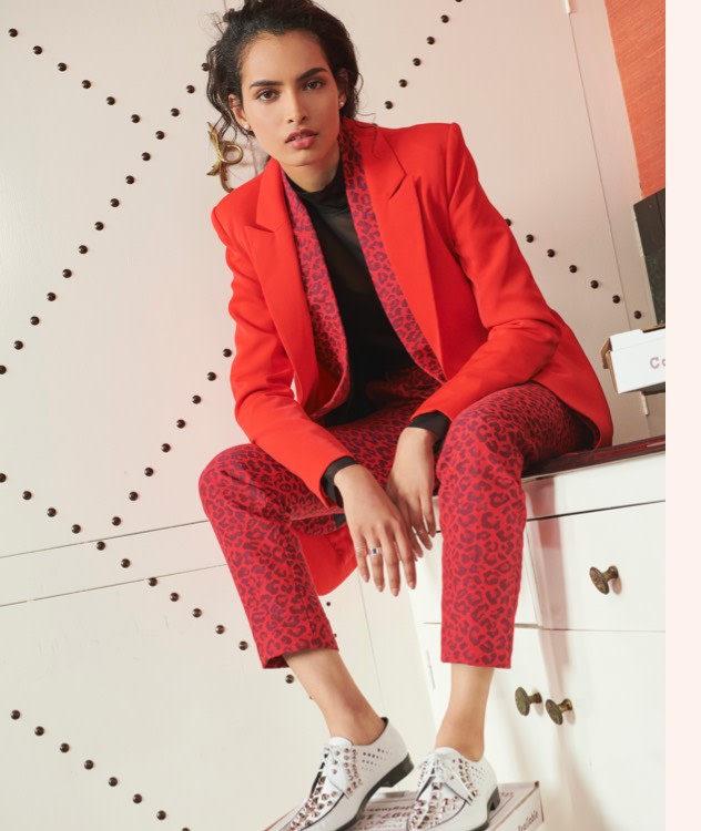 Layer red blazers with animal print slacks for a bold look.
