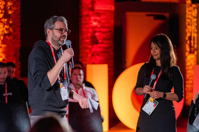 Three very excited protagonists on the HOD stage. One holds an oversized check with the inscription "Hands on Data - 5000€".