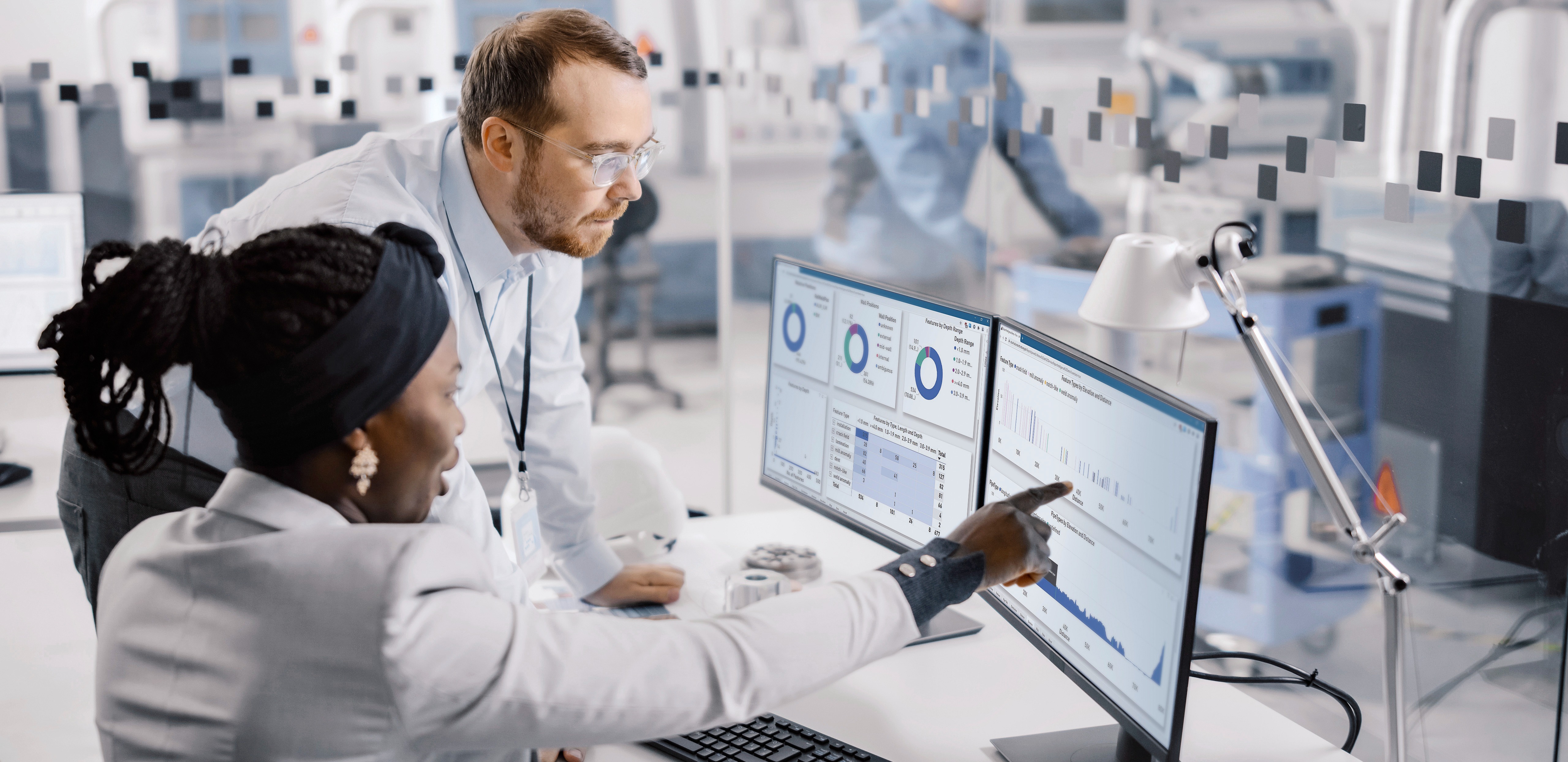 Man and woman looking at a data visualization on a monitor