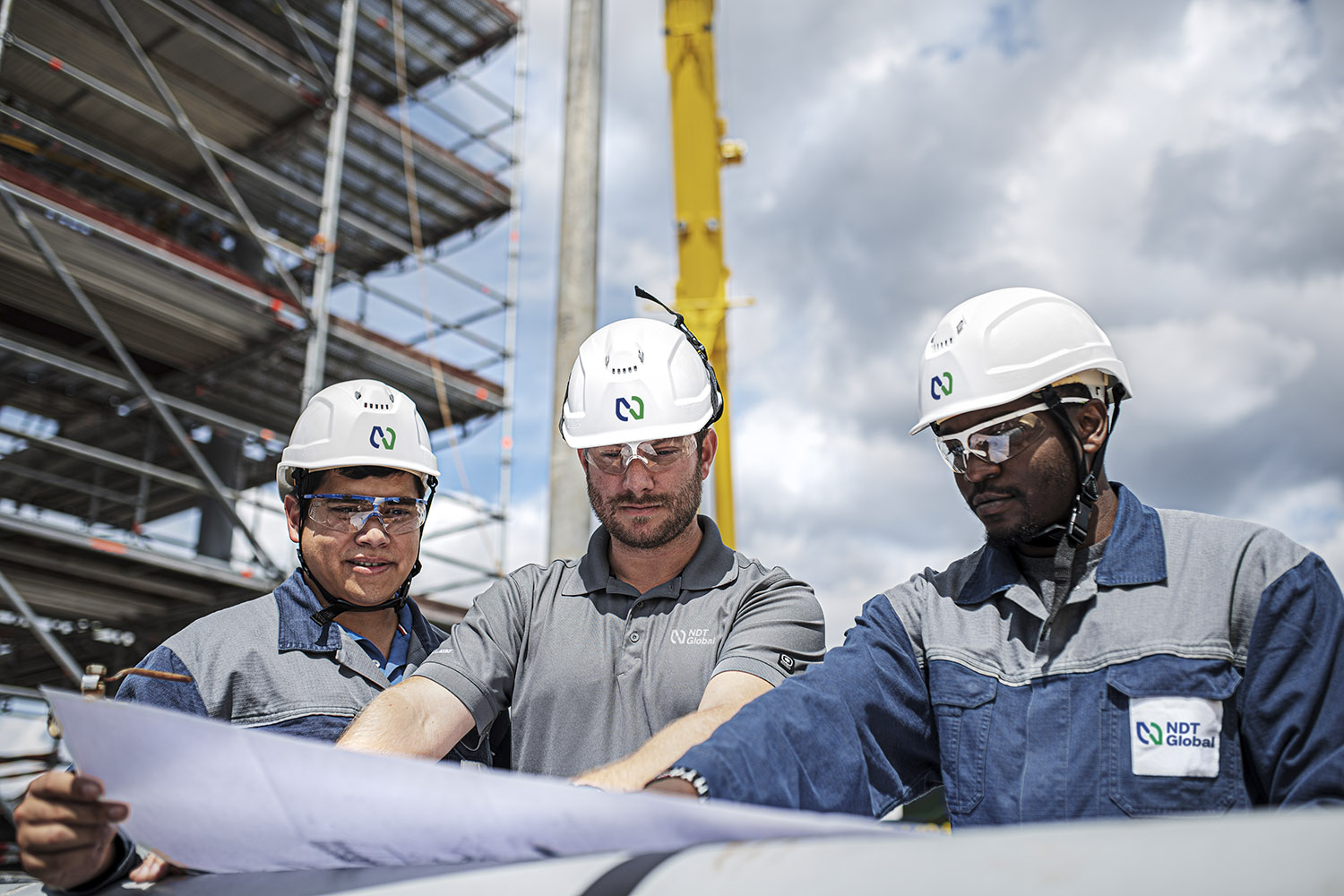 Three NDT Global men looking at a schematic