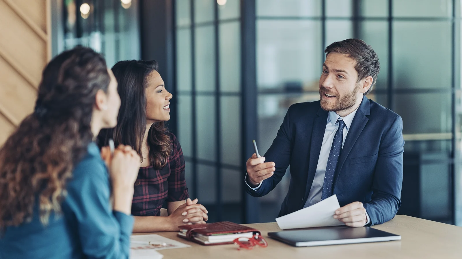 An investment banker speaks with a pair of women about options for investing - CDs and savings accounts.