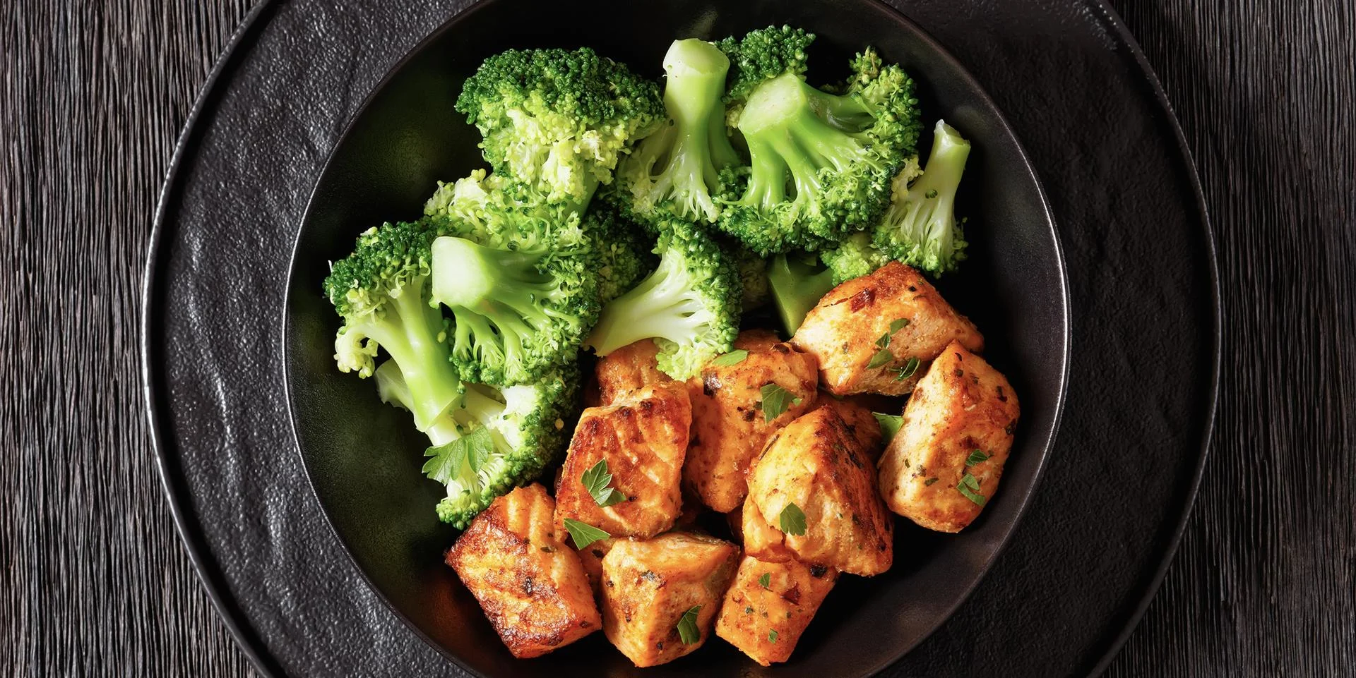A plate of salmon bites and broccoli.