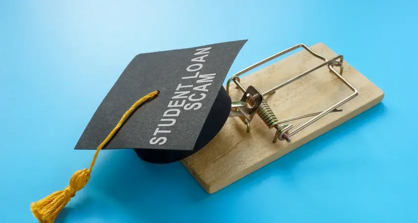 A graduation cap that reads student loan scam sitting on top of a mouse trap