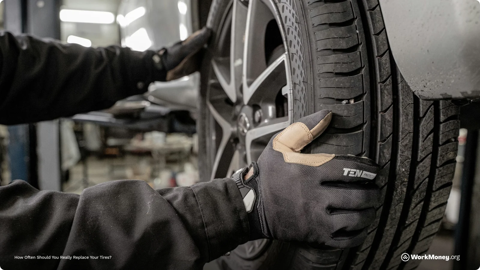 Mechanic places a new tire on a car.