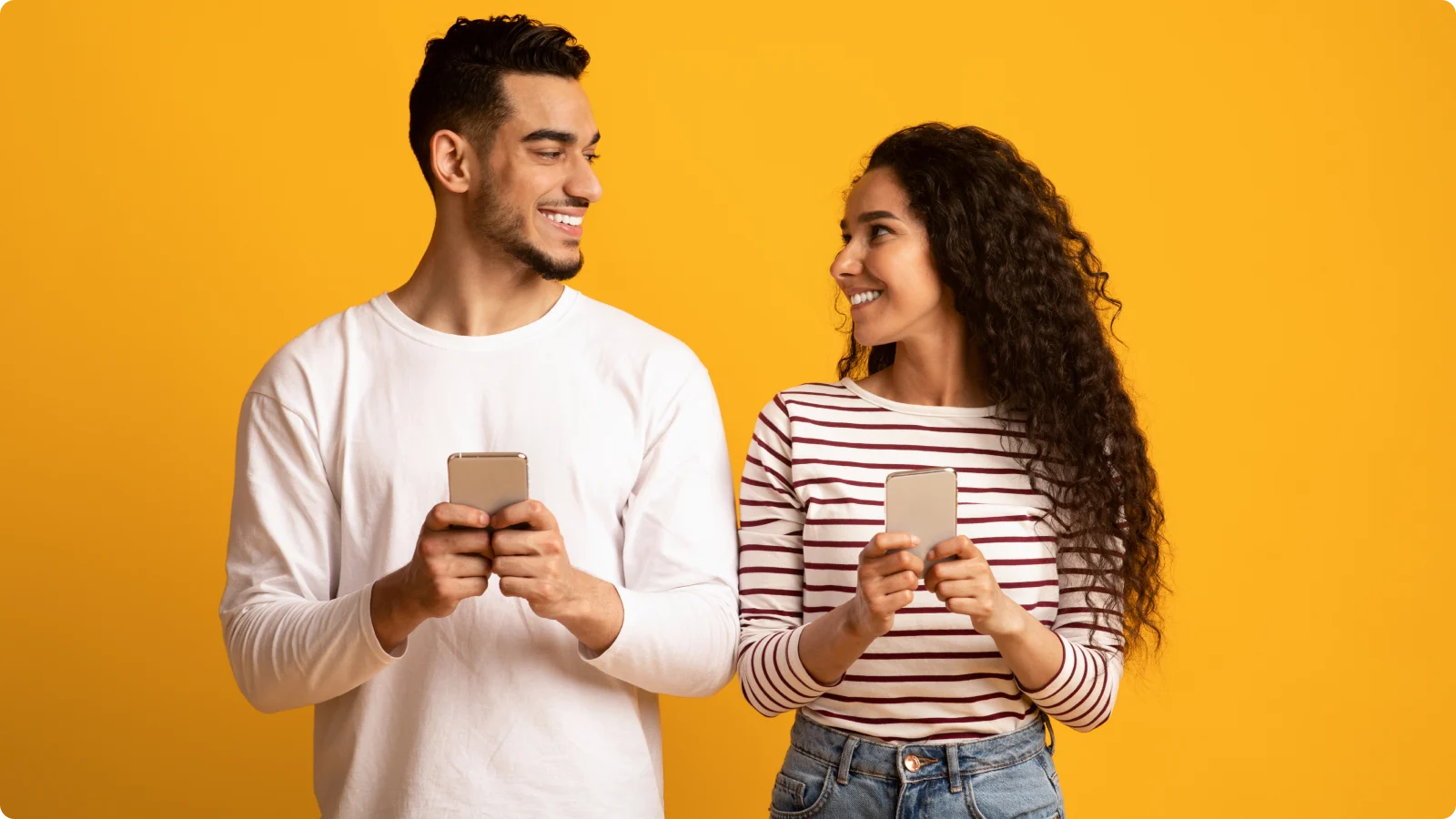 Two People Looking at each other over their phones.