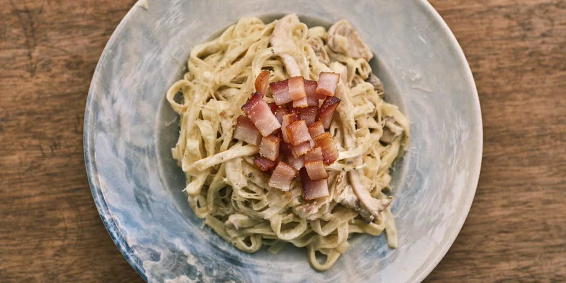 A plate of bacon alfredo.