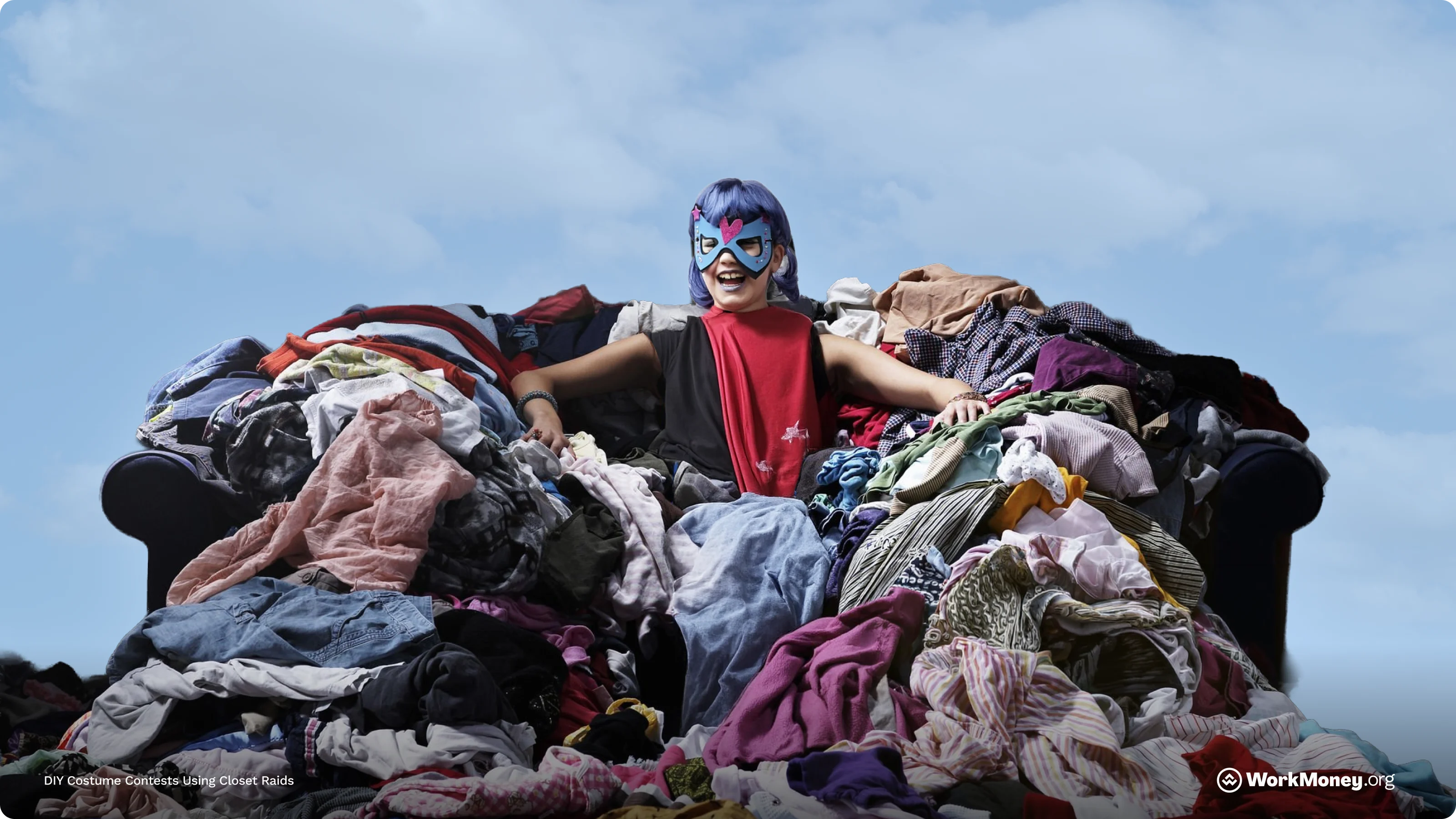 A woman wears a superhero mask standing in a pile of laundry