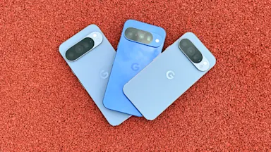 Tre blå mobiler med Googles logotyp ligger på en röd yta.