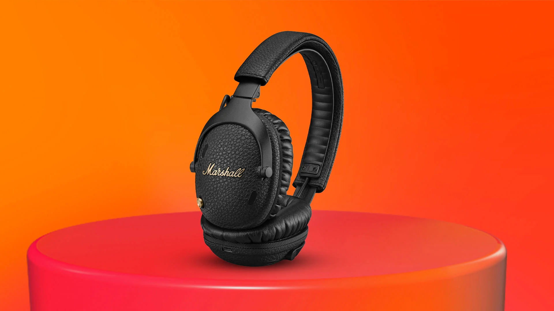 Svarta hörlurar på en röd piedestal mot en orange bakgrund.