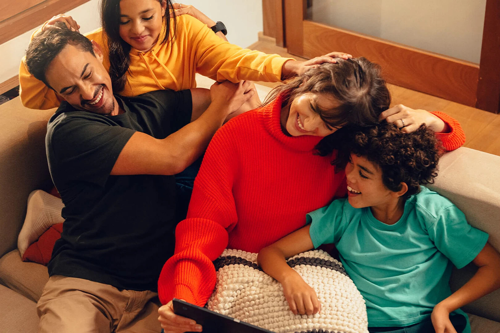 Familj i soffa tittar på surfplatta barn hemma