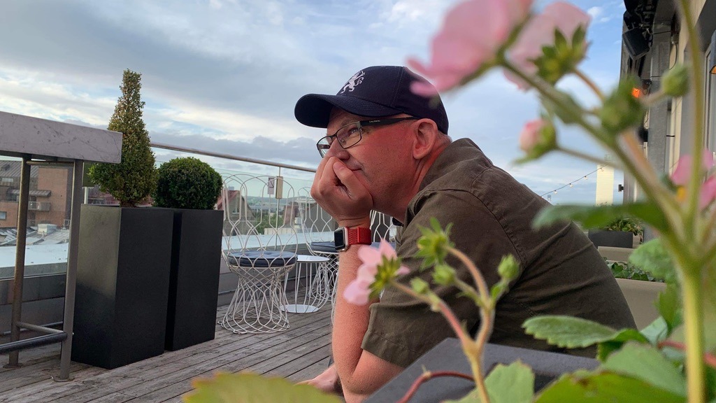 man sitter med keps och grå T-shhirt, tittar ut i horizonten