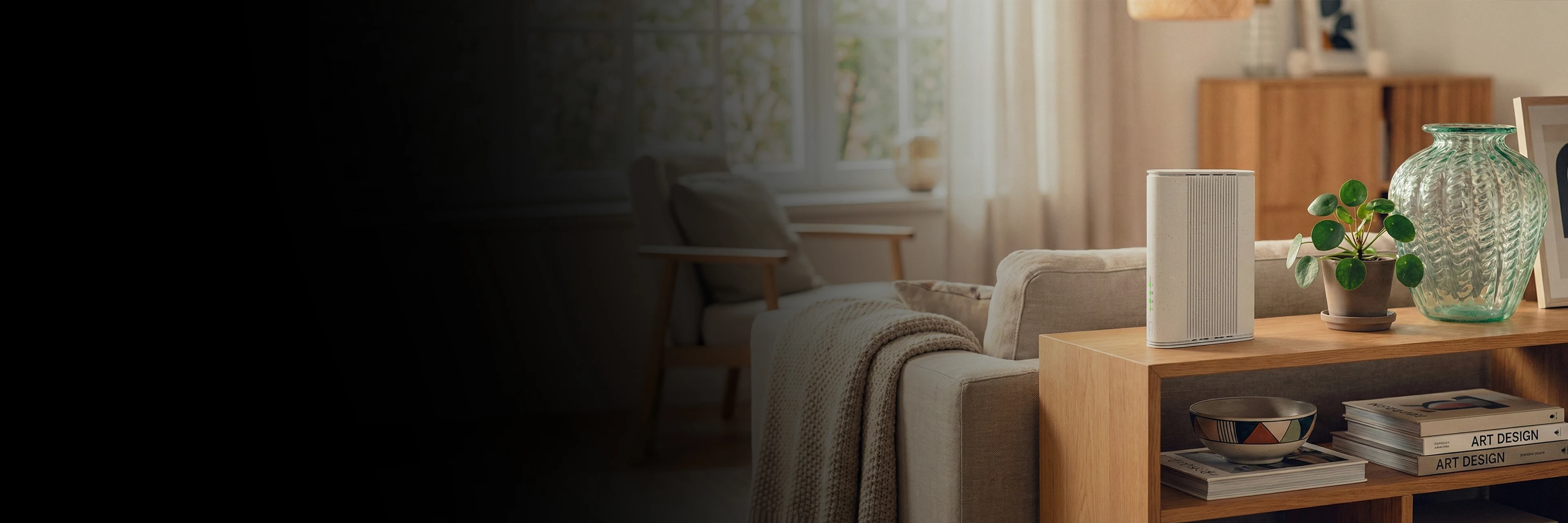 Router på träbord med växt och glasvas i ett ljust vardagsrum. Soffa och fönster i bakgrunden.